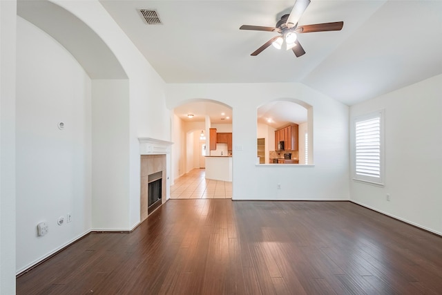 unfurnished living room featuring light wood-style floors, ceiling fan, visible vents, and vaulted ceiling