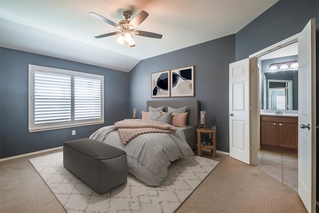 bedroom with light carpet, connected bathroom, vaulted ceiling, ceiling fan, and baseboards