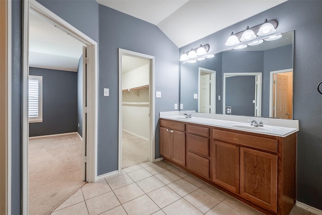 full bath with lofted ceiling, tile patterned floors, a sink, and double vanity