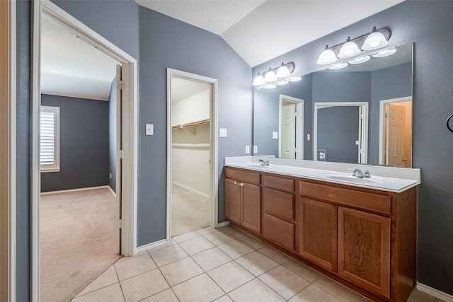 15646 Gatehouse Dr, Fort Worth, TX 76262 - bathroom featuring lofted ceiling, double vanity, tile patterned floors, baseboards, and a walk in closet