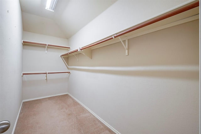 spacious closet featuring carpet floors and vaulted ceiling