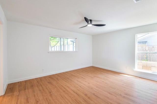 spare room with ceiling fan and light wood-type flooring