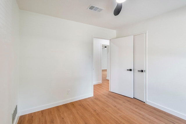 unfurnished bedroom featuring ceiling fan, light hardwood / wood-style floors, and a closet