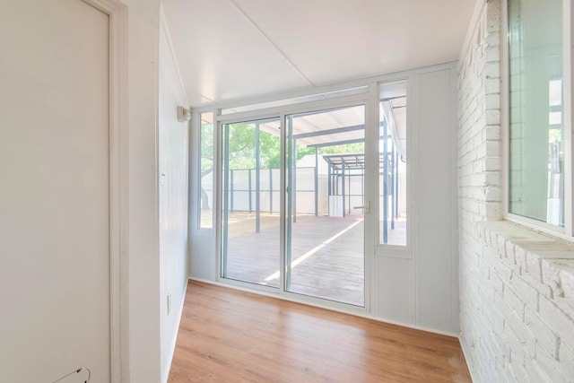 entryway featuring brick wall and light hardwood / wood-style flooring