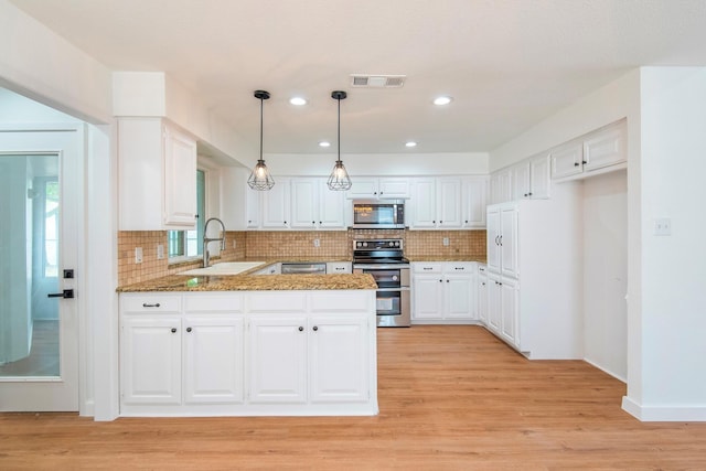 kitchen featuring white cabinetry, stainless steel appliances, and kitchen peninsula