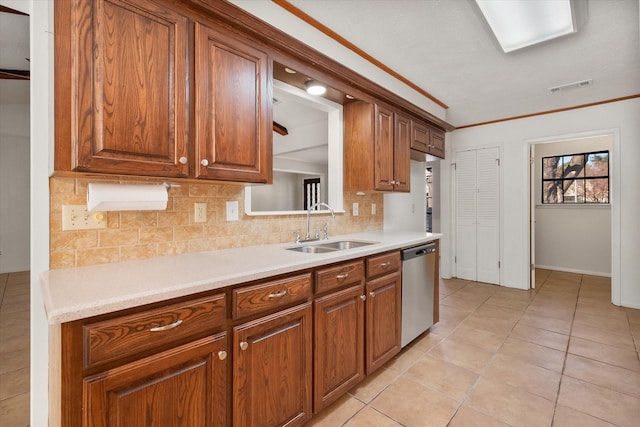 kitchen featuring sink, light tile patterned floors, crown molding, tasteful backsplash, and stainless steel dishwasher