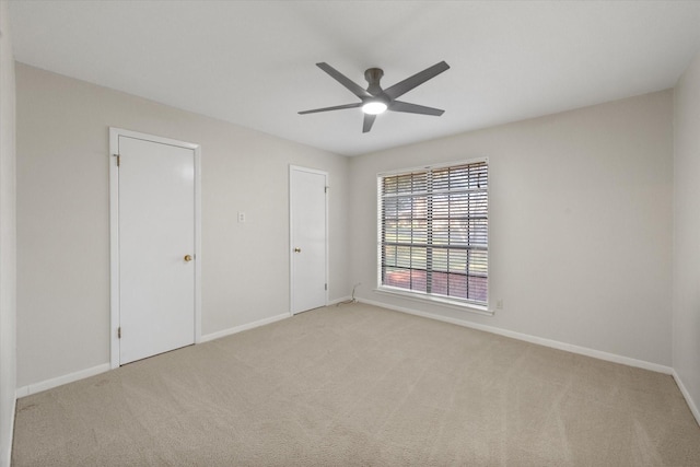 carpeted spare room featuring ceiling fan