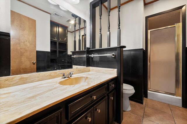 bathroom featuring vanity, toilet, an enclosed shower, and tile patterned flooring