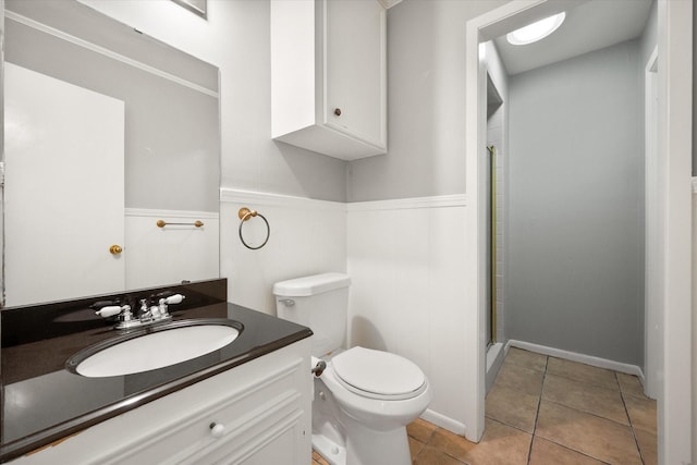 bathroom featuring vanity, tile patterned floors, toilet, and walk in shower