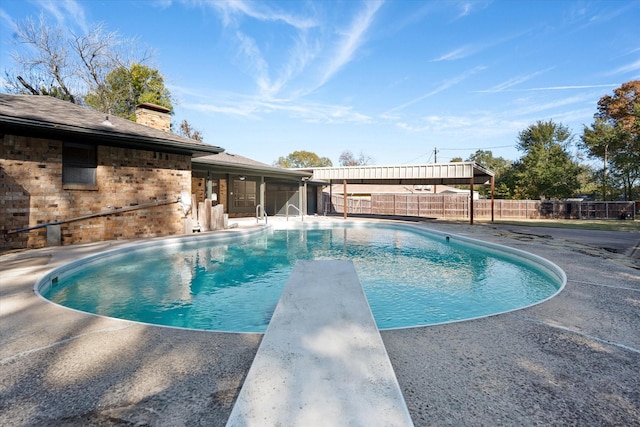 view of pool with a diving board