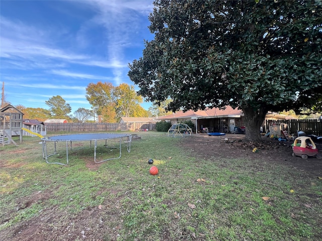 view of yard with a trampoline and a playground