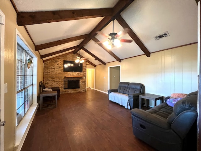 living room with vaulted ceiling with beams, a brick fireplace, ceiling fan, and dark wood-type flooring