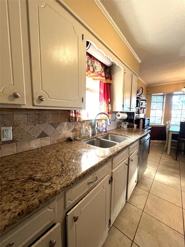 kitchen with sink, light tile patterned floors, stainless steel dishwasher, ornamental molding, and decorative backsplash