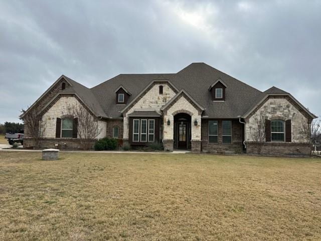 french country inspired facade featuring a front lawn