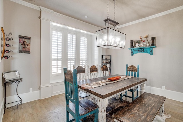 dining space with baseboards, crown molding, and wood finished floors