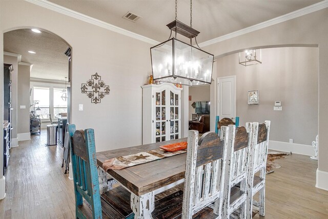 kitchen with stainless steel appliances, a large island with sink, a breakfast bar, and hanging light fixtures