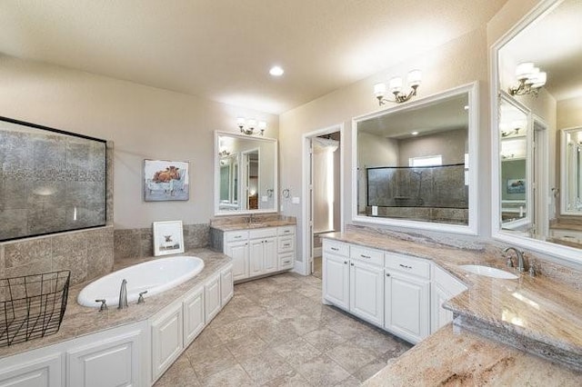 bathroom featuring separate shower and tub, a chandelier, and vanity