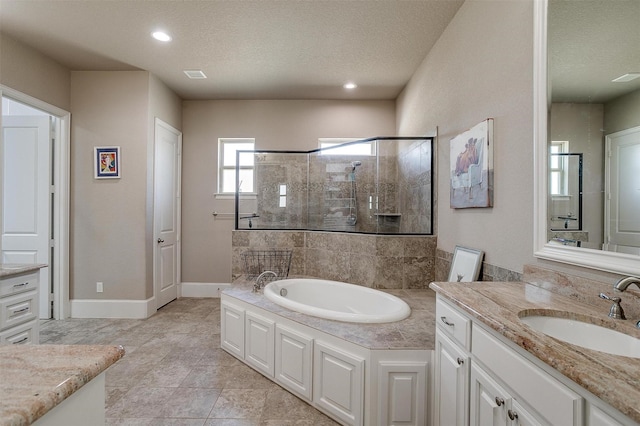 bathroom with a garden tub, a stall shower, a textured ceiling, vanity, and baseboards