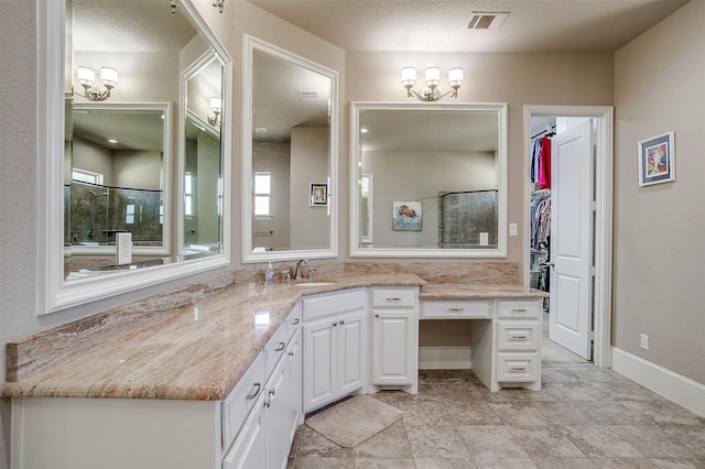 bathroom featuring visible vents, a spacious closet, vanity, and walk in shower