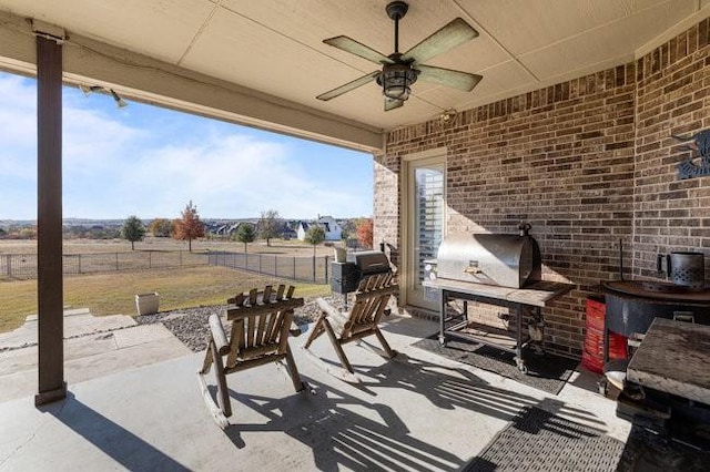 view of patio with ceiling fan and a rural view