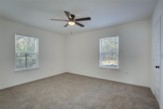 empty room featuring ceiling fan, carpet floors, and a healthy amount of sunlight