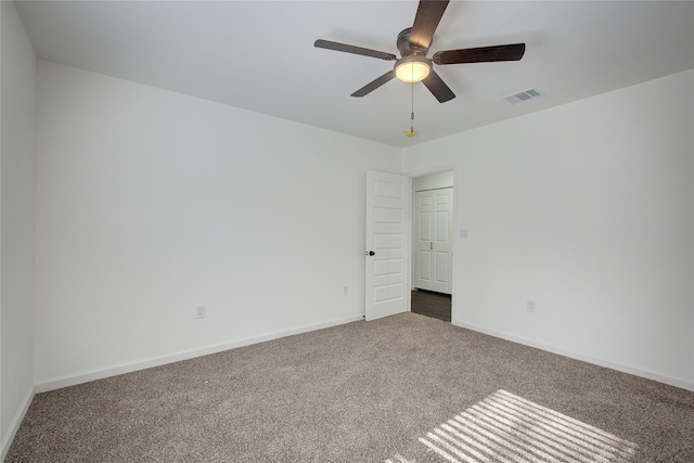 carpeted spare room featuring ceiling fan