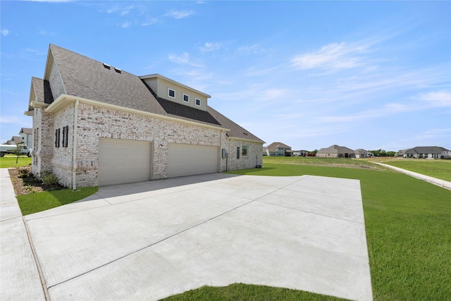5009 Tamarack Ln, Royse City, TX 75189 - view of side of property featuring roof with shingles, concrete driveway, a yard, a garage, and brick siding