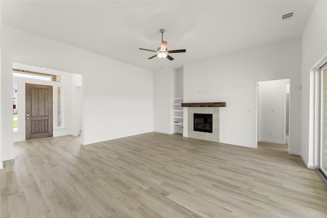 5009 Tamarack Ln, Royse City, TX 75189 - unfurnished living room featuring light wood-style floors, ceiling fan, a fireplace, and plenty of natural light