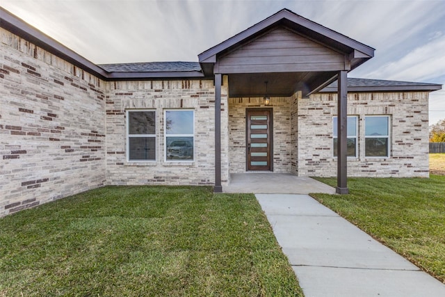 property entrance with a lawn