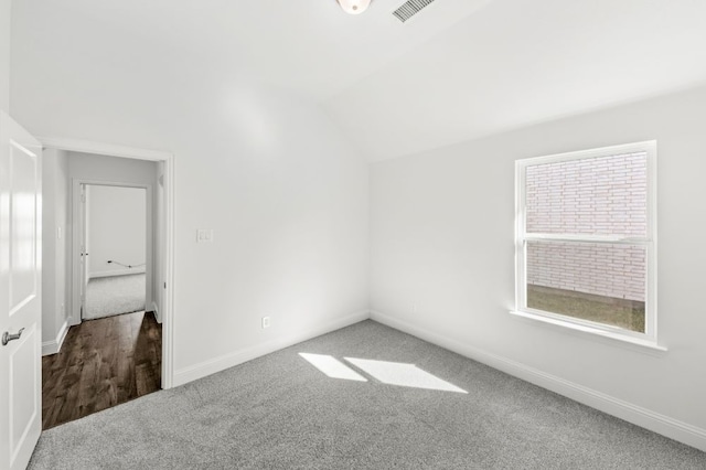 empty room with lofted ceiling and carpet flooring