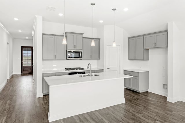 kitchen with decorative light fixtures, sink, appliances with stainless steel finishes, an island with sink, and gray cabinetry