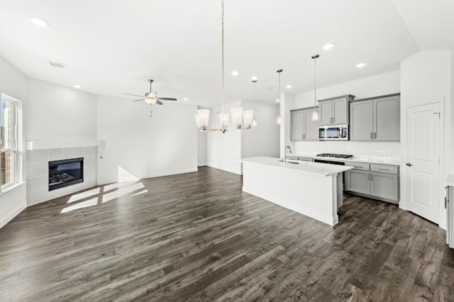 kitchen with pendant lighting, an island with sink, sink, ceiling fan, and gray cabinetry