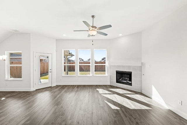 unfurnished living room featuring ceiling fan, vaulted ceiling, a fireplace, and hardwood / wood-style flooring