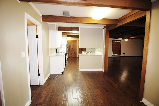 hallway featuring beam ceiling, dark hardwood / wood-style floors, ornamental molding, and sink