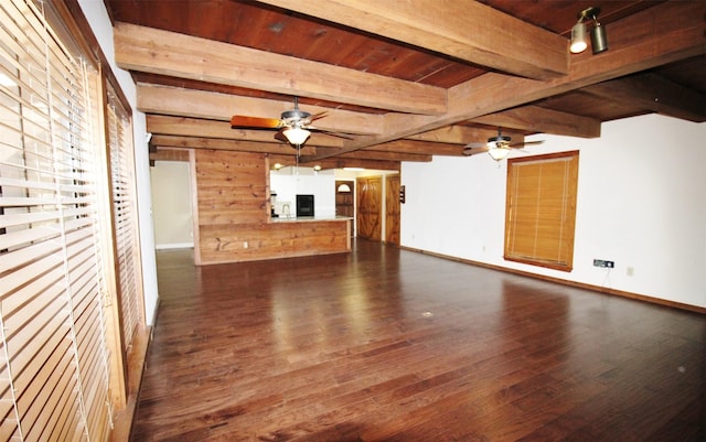 unfurnished living room featuring dark wood-type flooring, ceiling fan, wood ceiling, and beamed ceiling