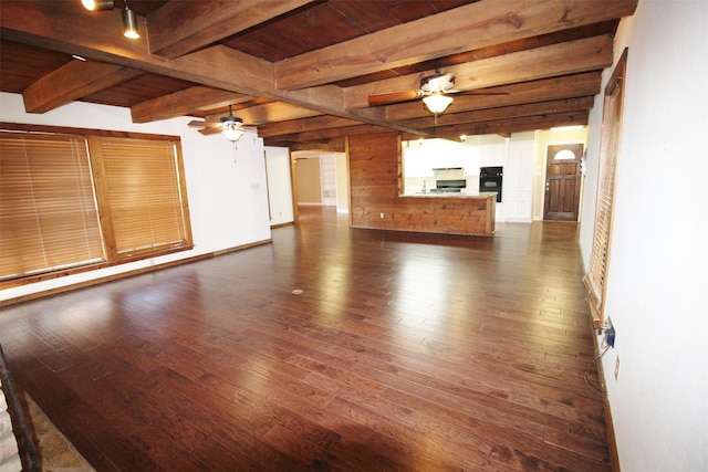 unfurnished living room featuring ceiling fan, beam ceiling, and dark hardwood / wood-style flooring