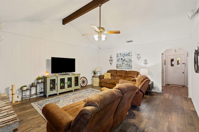 living room featuring vaulted ceiling with beams, ceiling fan, dark wood-type flooring, and a textured ceiling