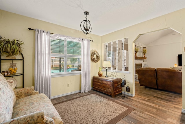 sitting room with a chandelier, a textured ceiling, and hardwood / wood-style flooring