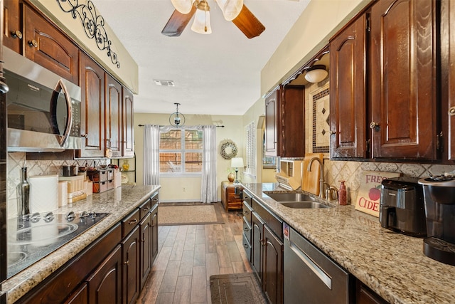 kitchen with decorative backsplash, stainless steel appliances, sink, decorative light fixtures, and dark hardwood / wood-style floors