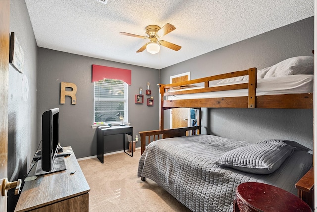 carpeted bedroom with ceiling fan and a textured ceiling