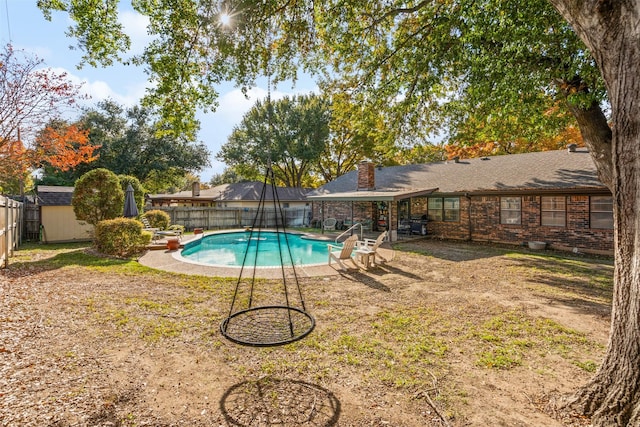 view of pool featuring a yard and a storage unit