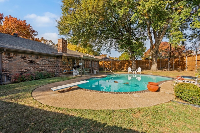 view of pool featuring a yard, a diving board, and a patio area