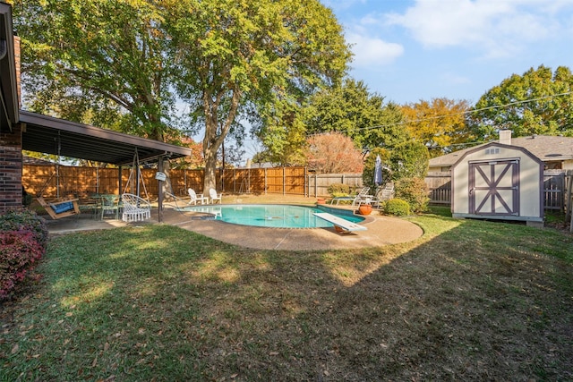 view of pool featuring a lawn, a diving board, a storage shed, and a patio area