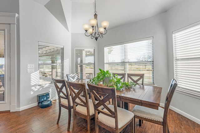 dining area with a notable chandelier, dark hardwood / wood-style floors, and lofted ceiling