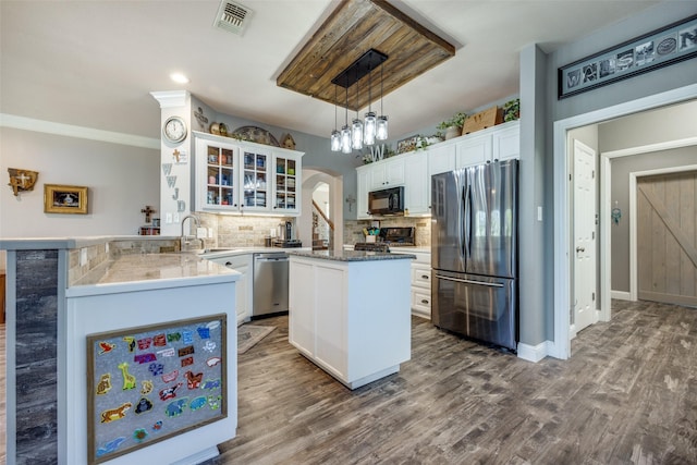 kitchen featuring kitchen peninsula, decorative light fixtures, white cabinets, black appliances, and hardwood / wood-style flooring