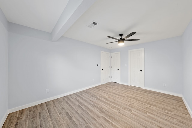 spare room with beamed ceiling, ceiling fan, and light wood-type flooring