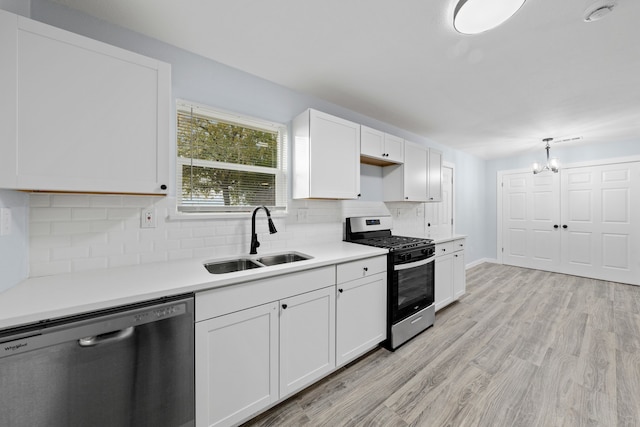 kitchen with white cabinets, light wood-type flooring, stainless steel appliances, and sink