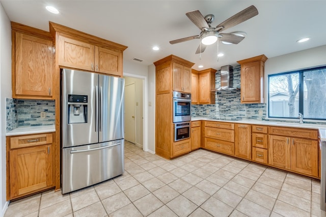 kitchen featuring backsplash, wall chimney range hood, sink, ceiling fan, and appliances with stainless steel finishes