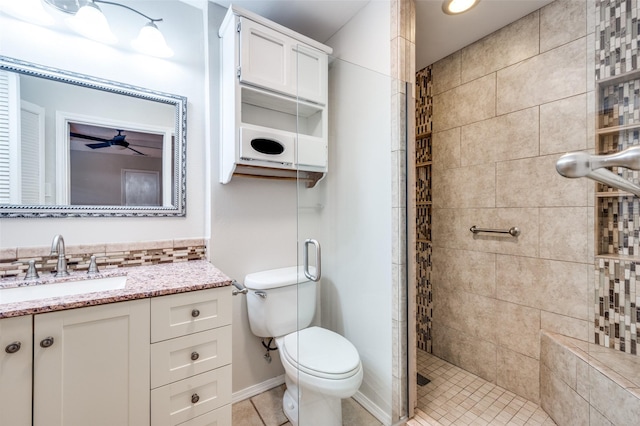 bathroom featuring tile patterned floors, vanity, toilet, and a shower with door