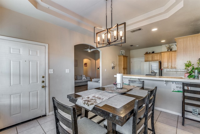 dining area featuring light tile patterned floors and a raised ceiling